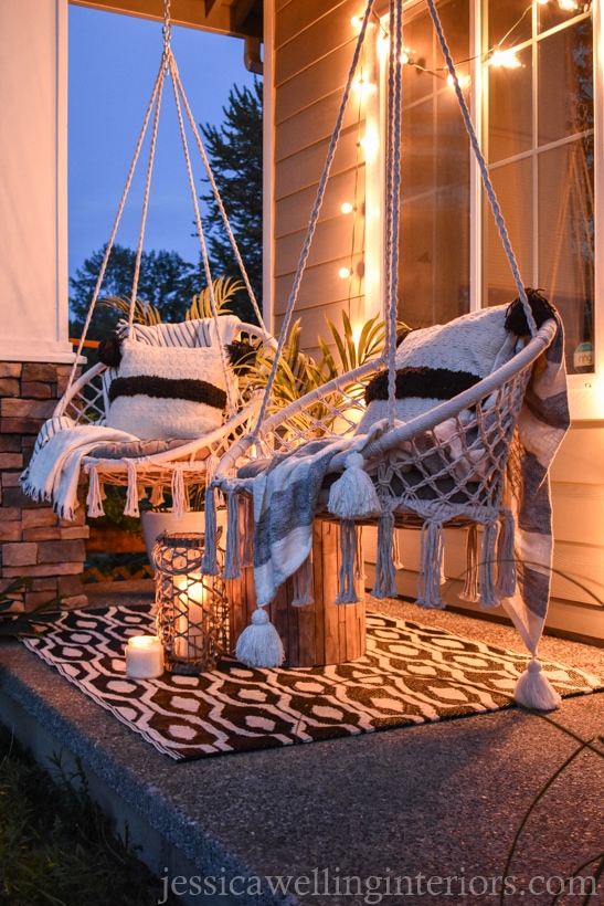 front porch with macrame swings and a black and white woven plastic outdoor rug