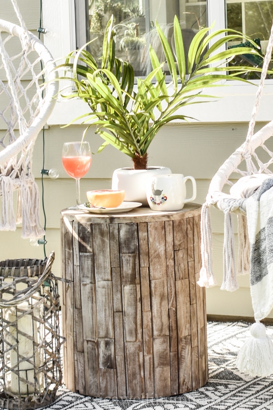 close-up of wood outdoor end table in boho-style outdoor living room