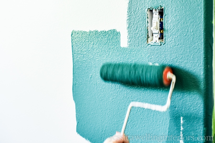 teal paint being rolled onto a wall