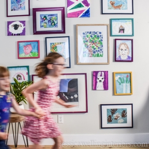 kids art display gallery wall with two kids running