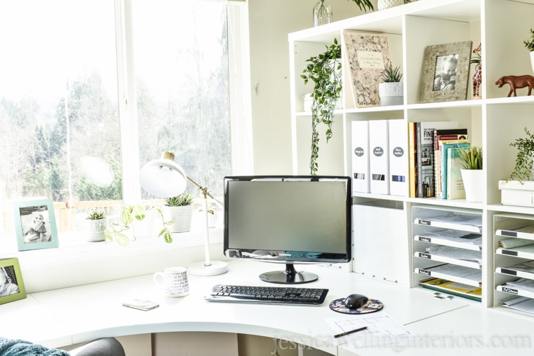 Ikea office design with modern white office furniture, a desk lamp, and indoor plants