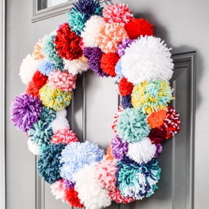 Boho pom pom wreath hung on a front door