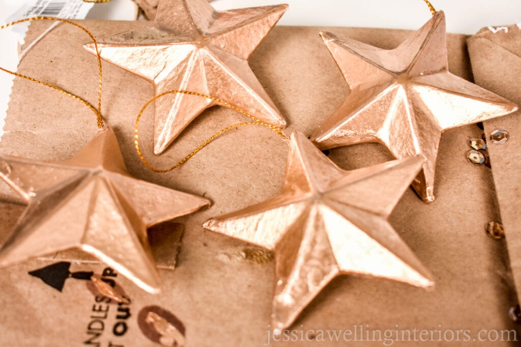 star-shaped handmade Christmas ornaments painted with gold leaf paint laid out to dry