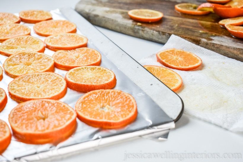 orange slices lined up on a baking sheet, ready to go into the oven