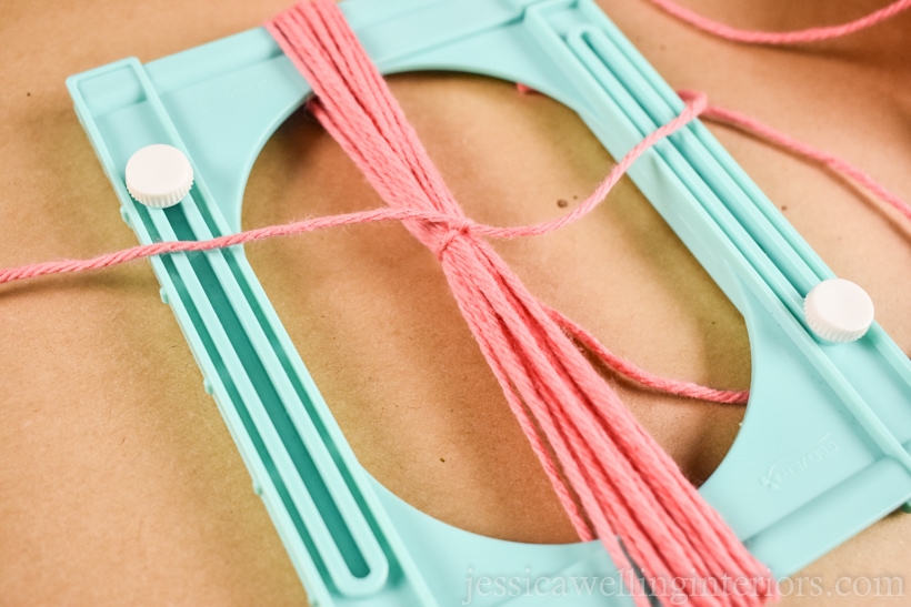 close-up of pink yarn tassel tied in the center with another length of pink yarn