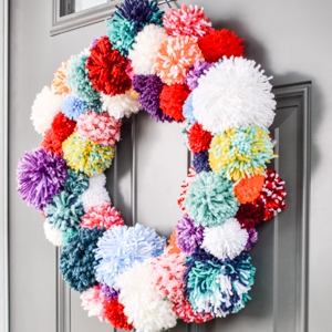 colorful pom pom wreath on a front door