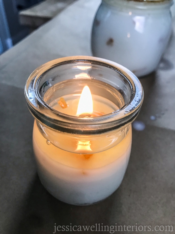 close-up of small mason jar candle burning with a full wax pool