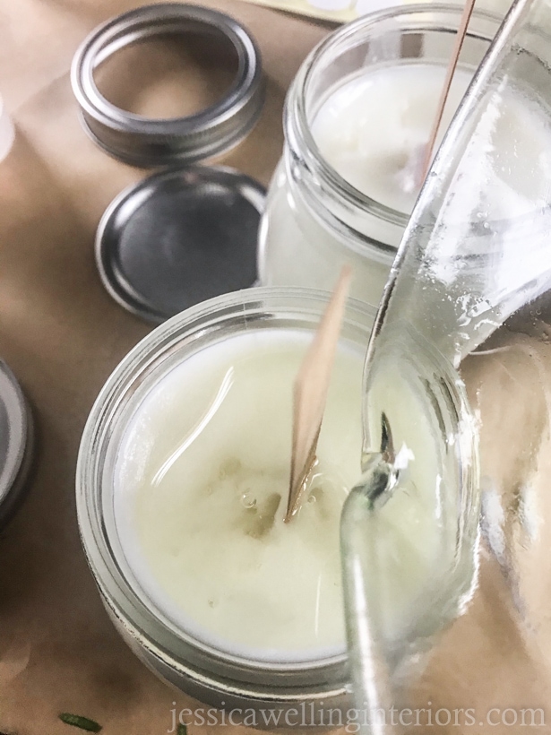 close-up of hot soy wax being poured over the top of a wood wick soy candle to finish it