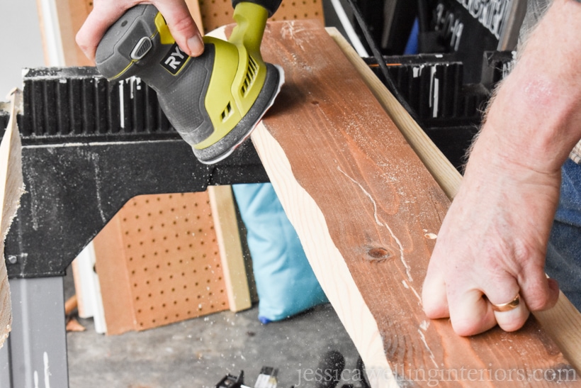 diy coat rack being sanded with an orbital sander before stain is applied