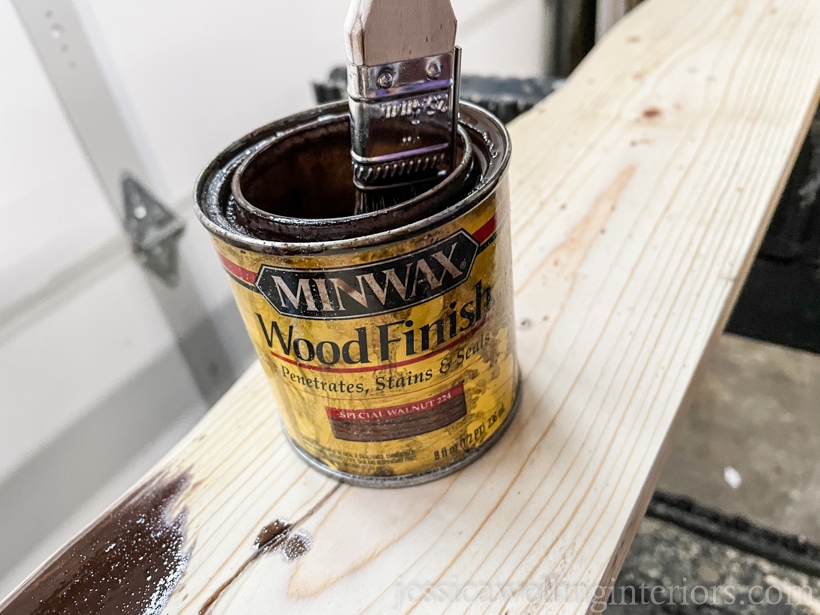 special walnut-colored wood stain being applied to an unfinished wooden coat rack