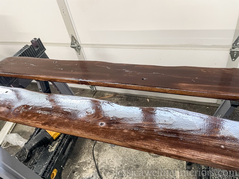 2 diy wall hook racks laying on top of sawhorses with wet stain