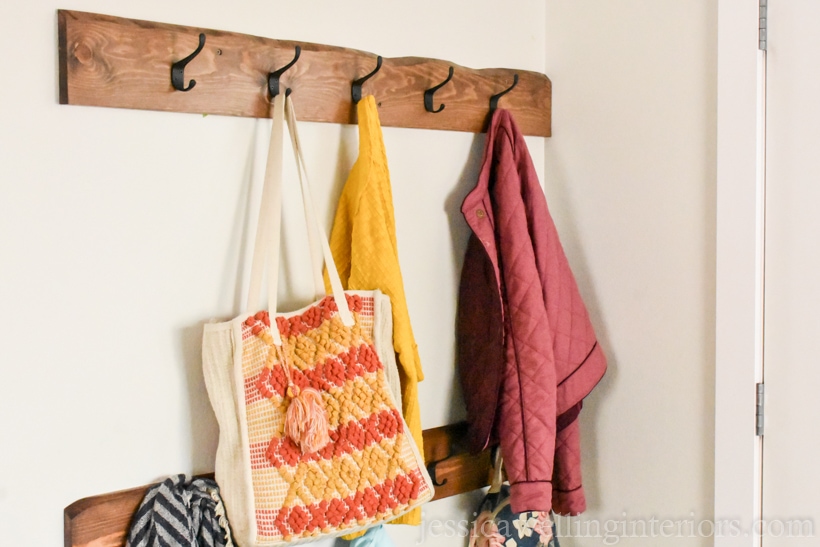 modern coat rack in a small entryway with a Boho purse and jacket hanging from it