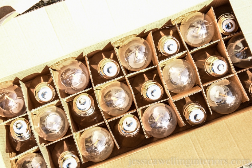 box of string light bulbs ready to be hung over a patio