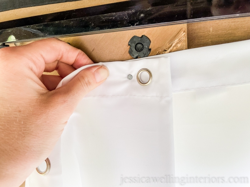 close-up of outdoor curtain panel being nailed to hang it up in an outdoor living room