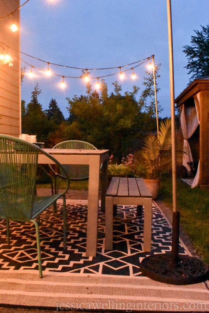 patio with an umbrella stand outdoor string light pole in the foreground