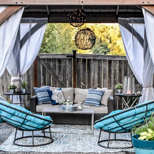 gazebo with outdoor papasan chairs, outdoor curtains, and lights