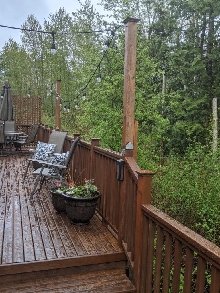 deck with string light posts attached to the deck railing