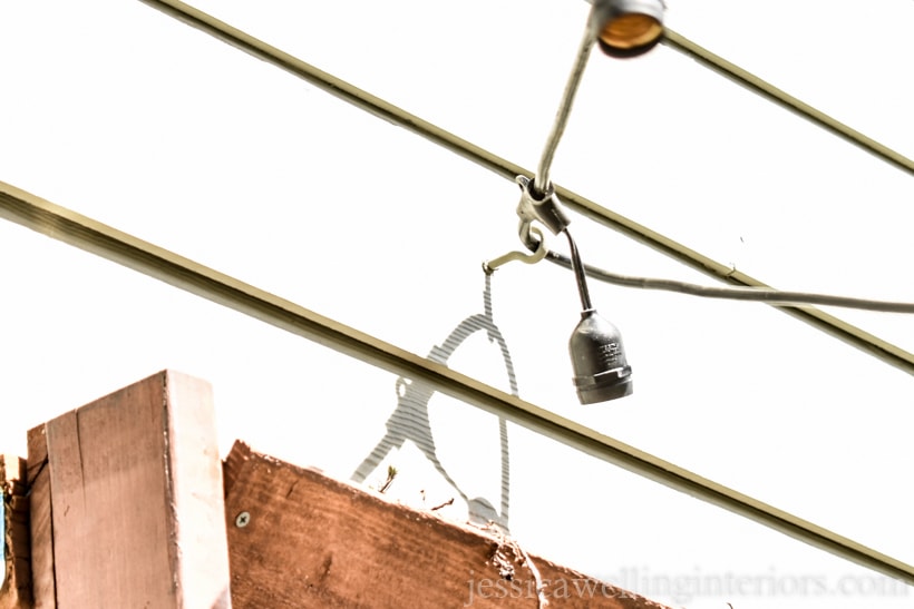 string lights attached to a cup hook mounted on the side of a house