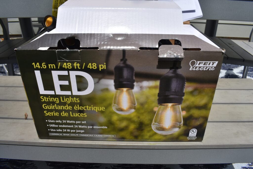 opened box of Feit Electric LED string lights sitting on a patio table