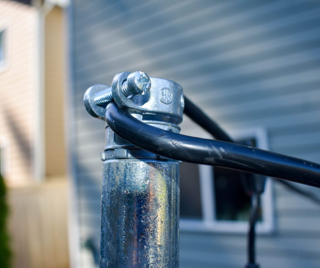 close-up of the top of an electrical conduit string light pole showing how to attach the string lights to the pole