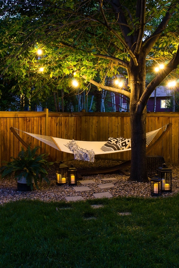 glowing string lights hung in the branches of a tree over a hammock