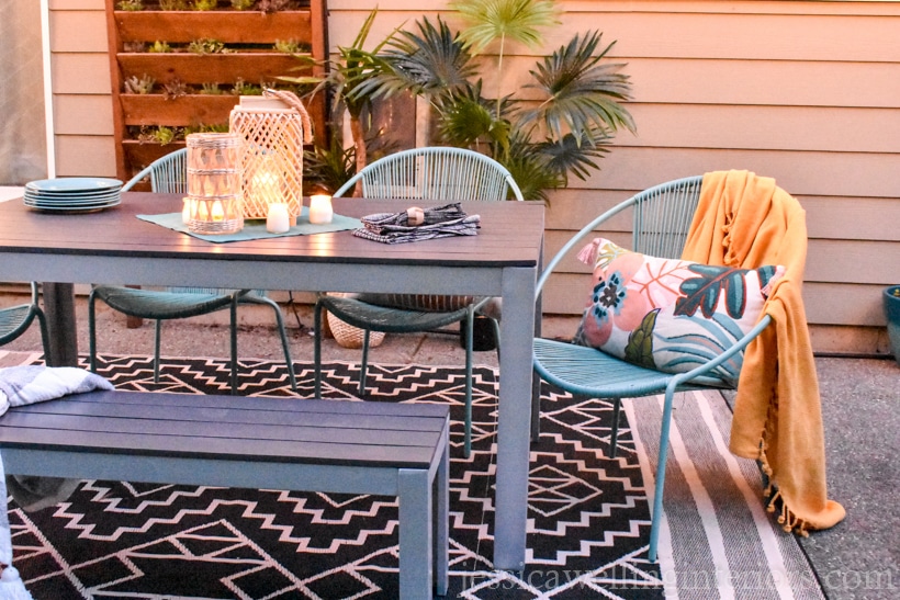 patio with an outdoor dining table and a woven plastic outdoor rug from Fab Habitat