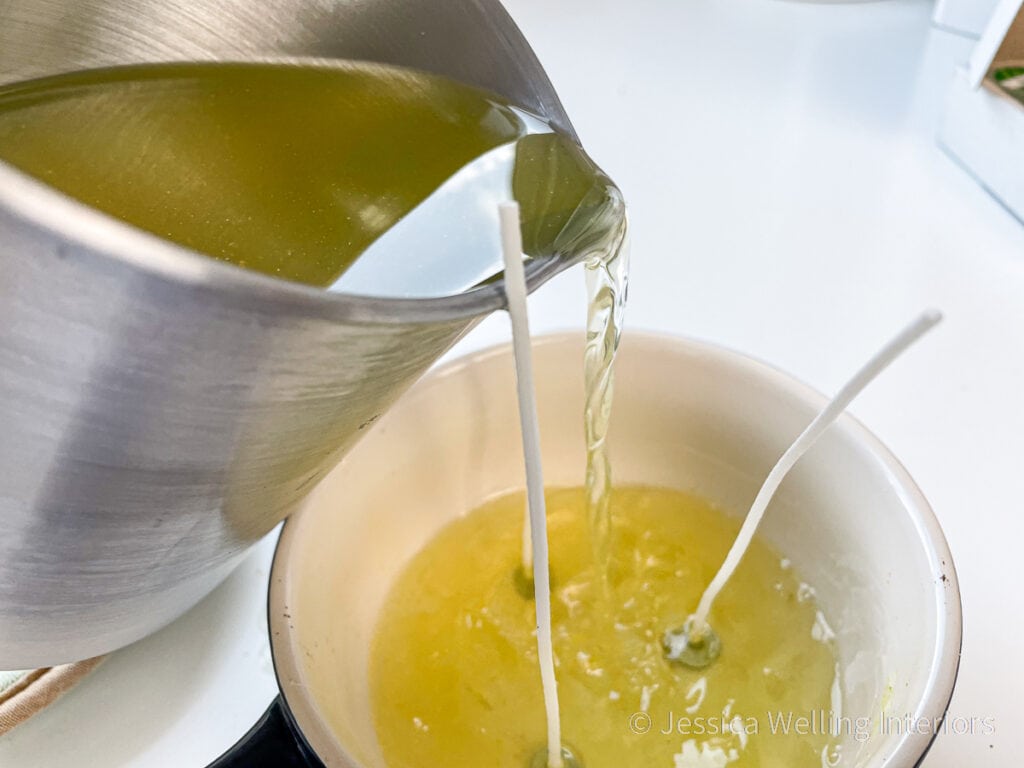 hot wax being poured into a bowl with 3 candle wicks to make a DIY citronella candle