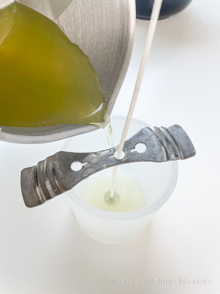 close-up of citronella candle wax being poured into a glass candleholder