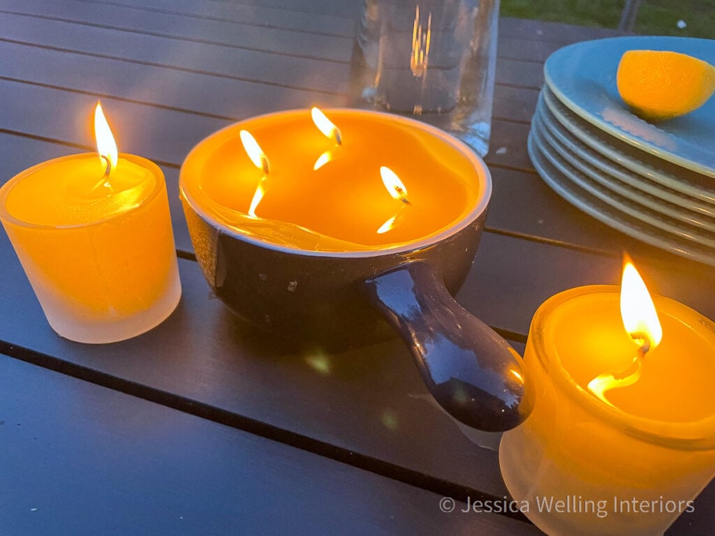 Citronella candles lit on a patio table