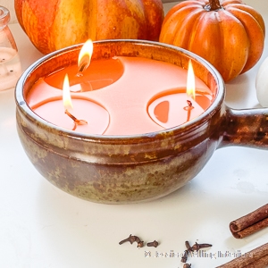 rustic DIY Fall scented candle with three wicks and pumpkins in the background