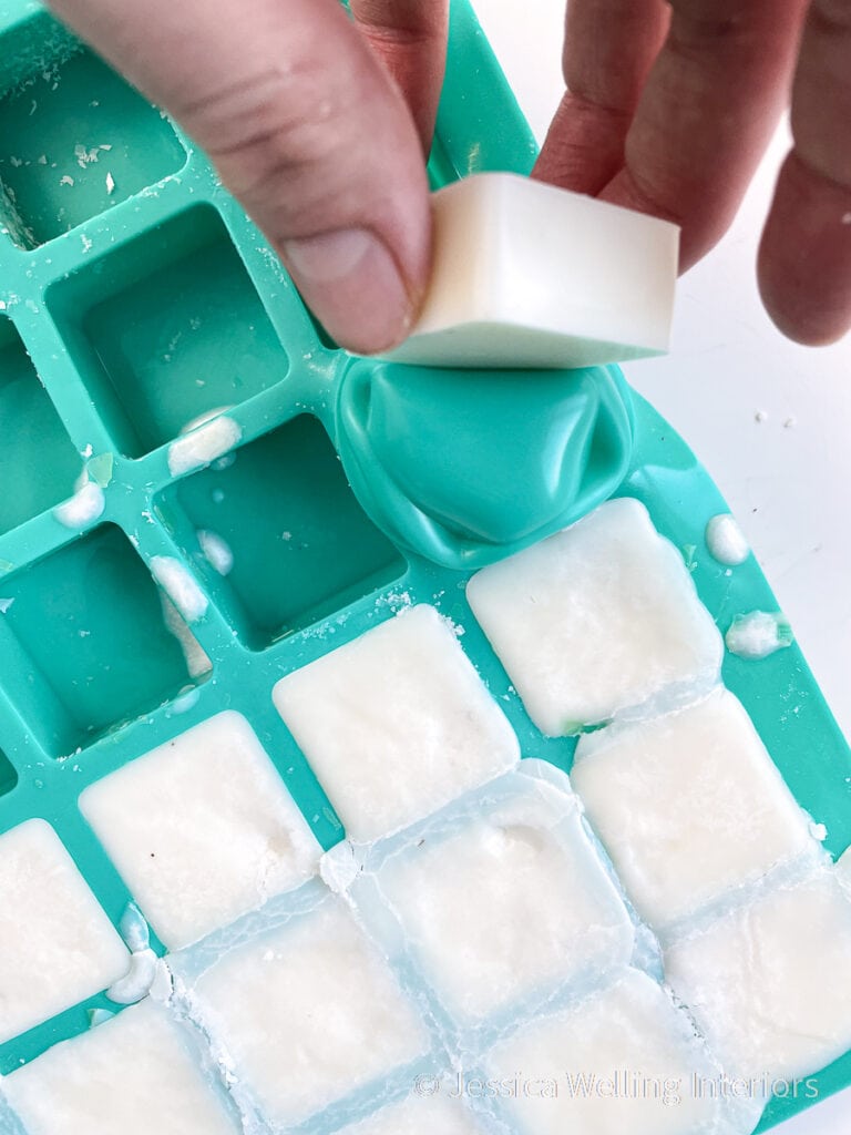 hand removing soy wax melts from a silicone candy mold