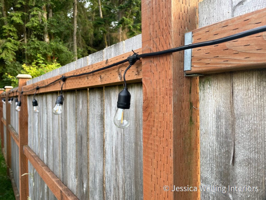 heavy-duty string lights attached to a fence with finish nails