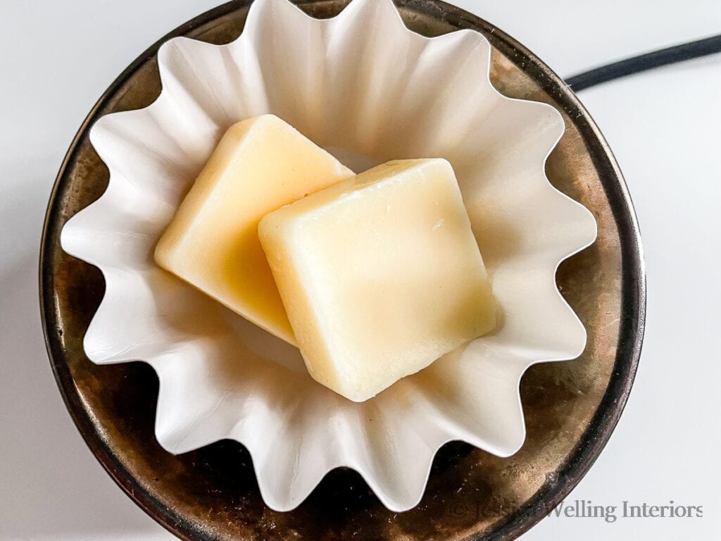 wax warmer with a white paper liner and two square-shaped scented wax melts inside