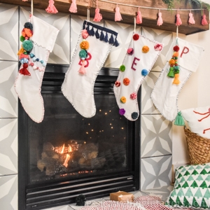 farmhouse mantel with modern boho Christmas stockings hanging from it
