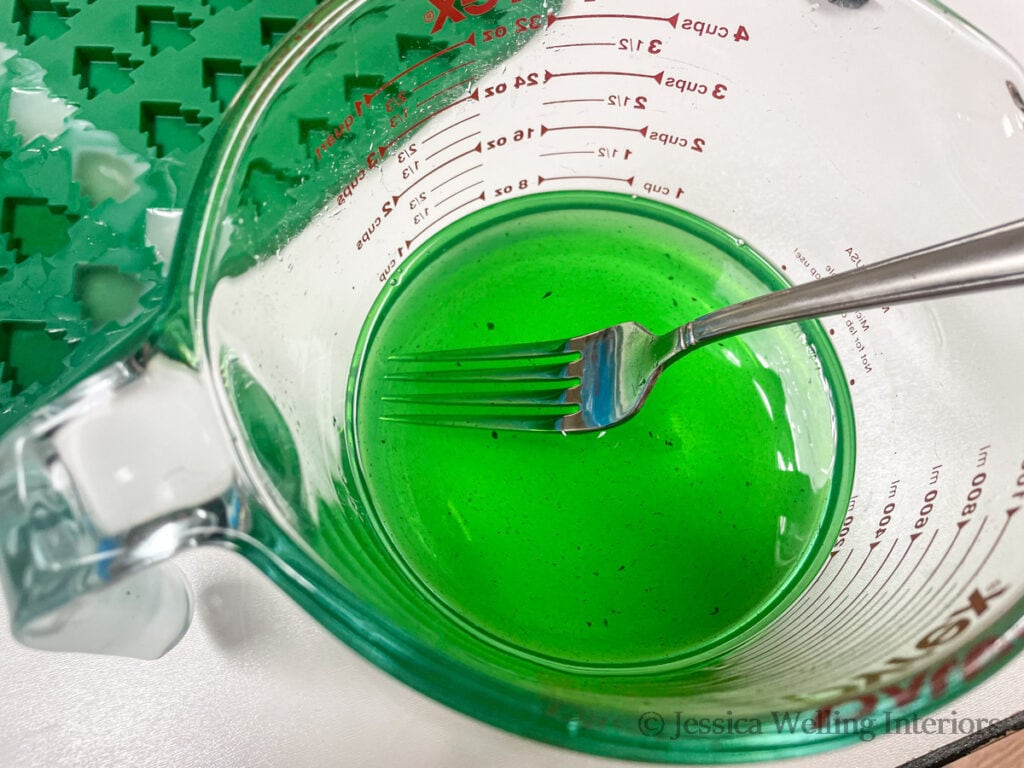 melted green scented wax in a large glass measuring cup