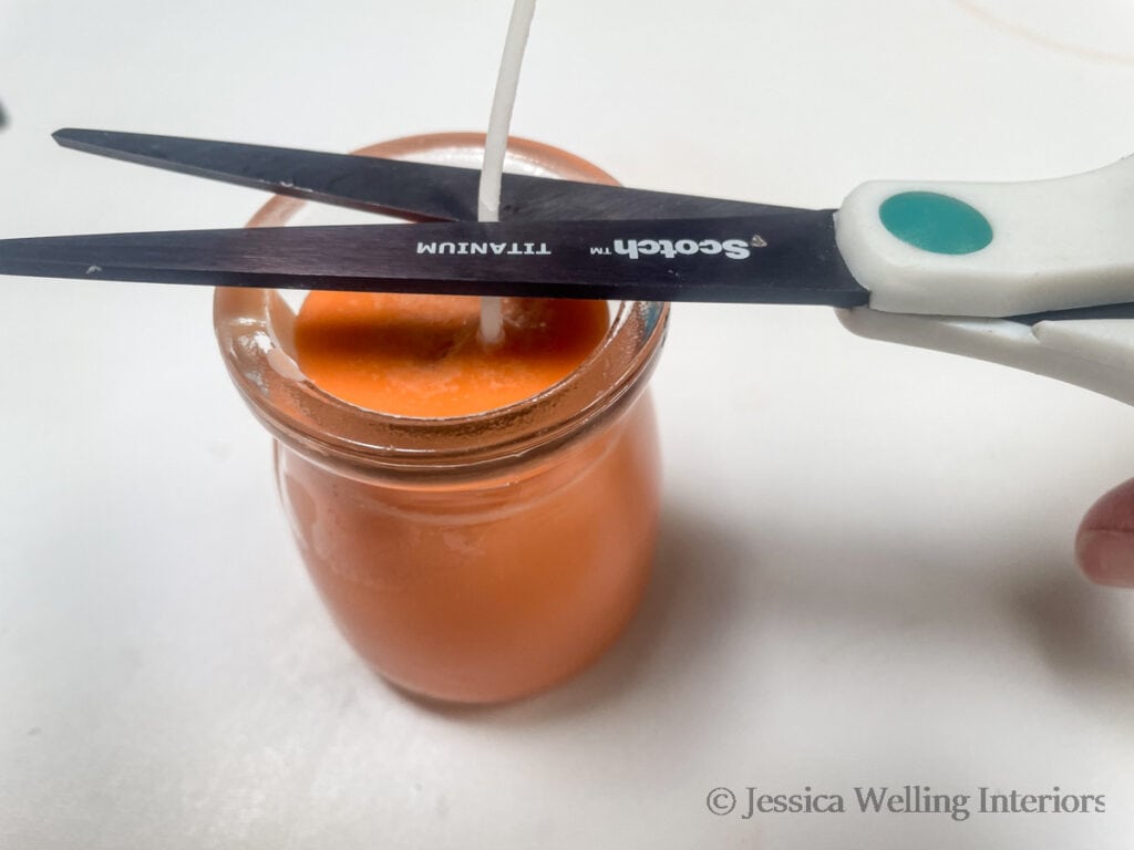 close-up of scissors trimming the wick on a handmade candle