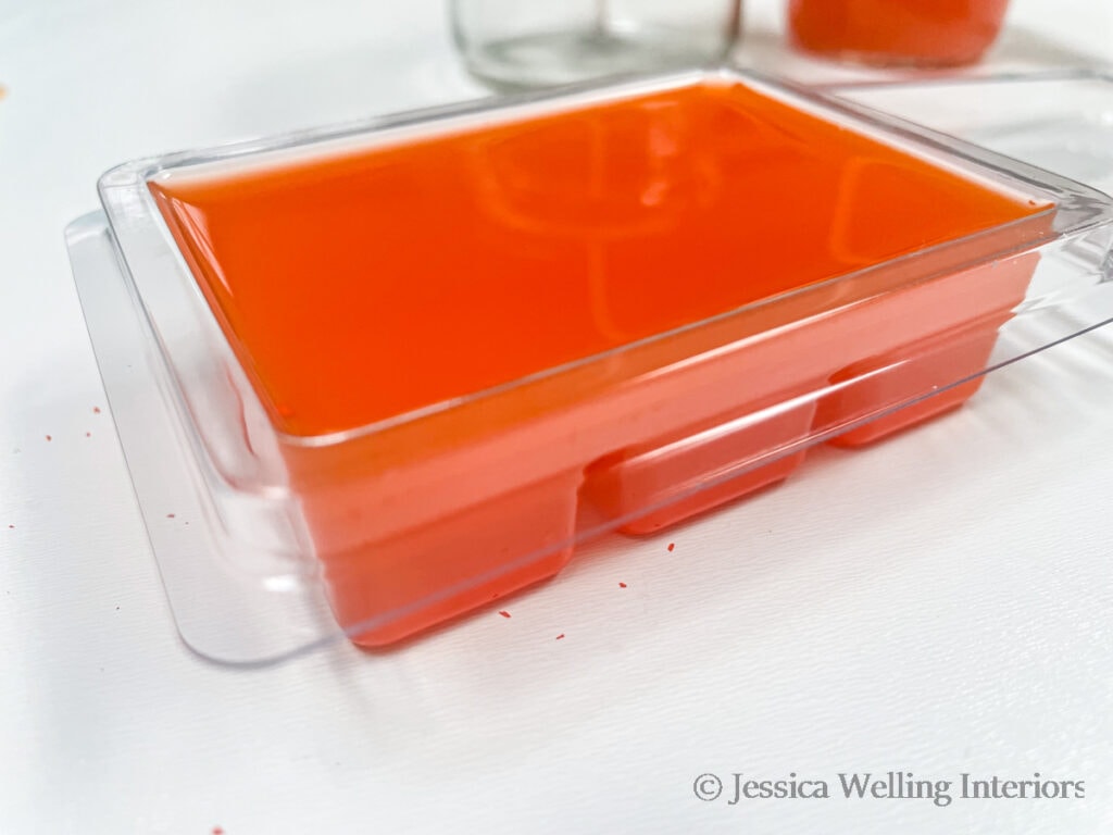 close-up of clamshell-style wax mold filled with orange soy wax