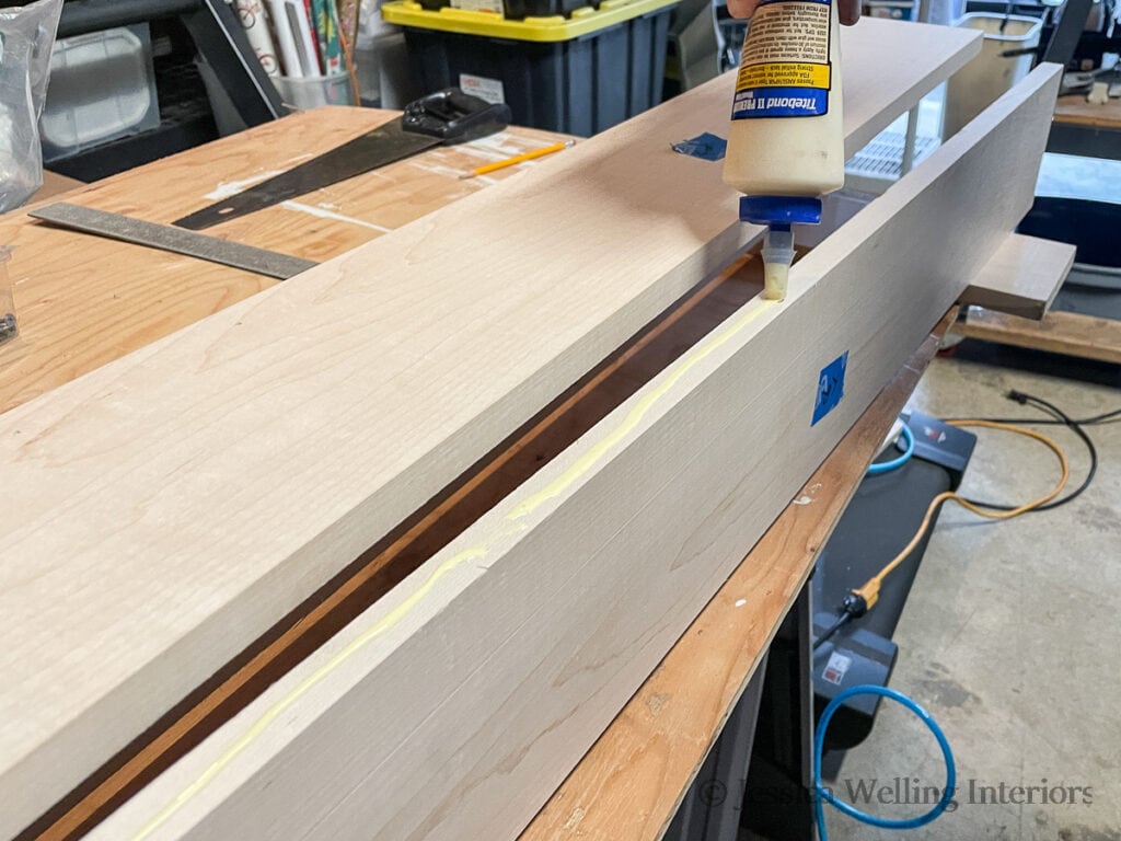 wood glue being applied to boards before attaching them together to make a mantel