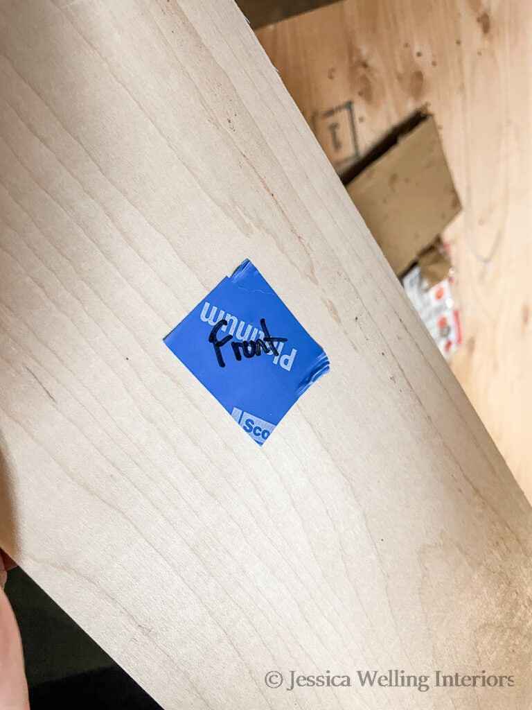 close-up of a board with a piece of painters tape labeled "front" 
