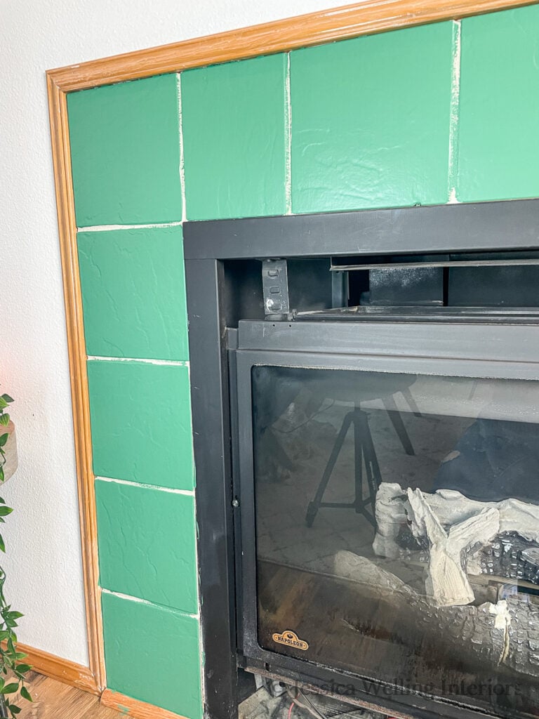 fireplace tile surround painted green and ready to be stenciled