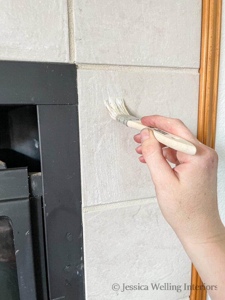 BIN primer being painted onto ceramic fireplace tiles with a disposable paintbrush