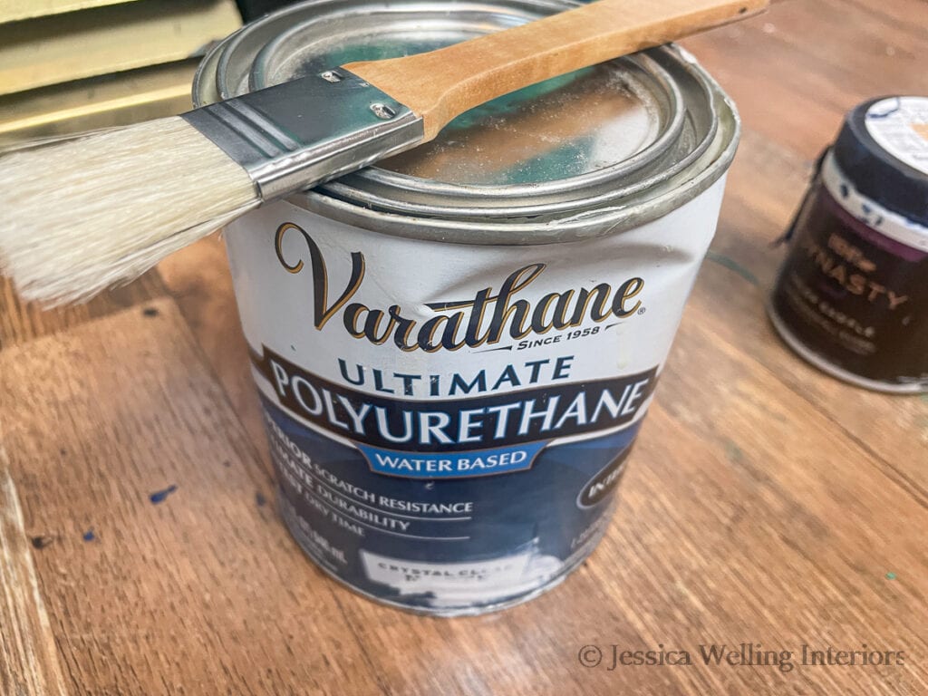 can of matte finish polyurethane with a paintbrush sitting on top