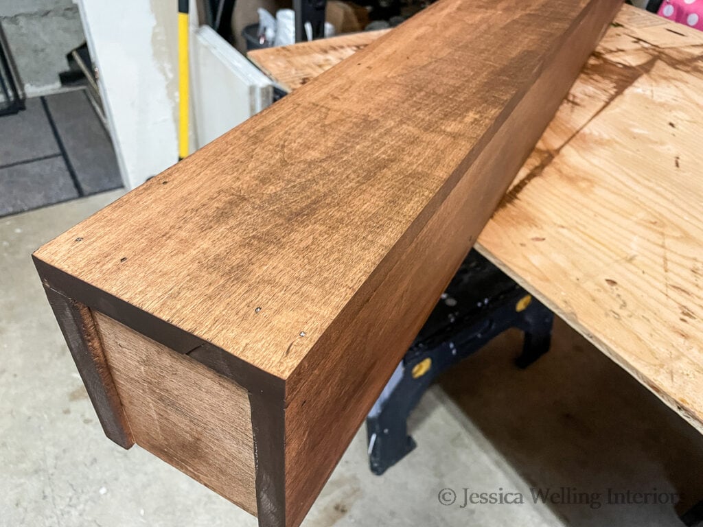 end of a handmade wood mantel with walnut colored wood stain