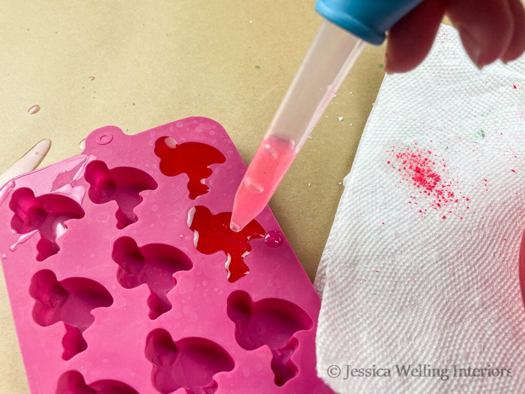 eye dropper filling a flamingo-shaped wax mold with hot soy wax