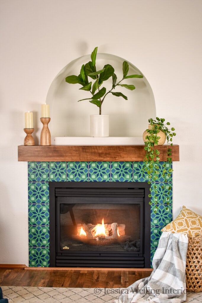 after painting fireplace tile: living room with Moroccan fireplace, wood mantel, and indoor plants