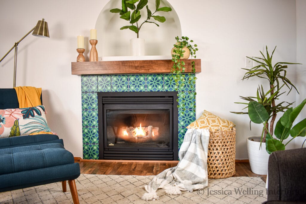 finished fireplace tile surround with a modern chair and indoor plants
