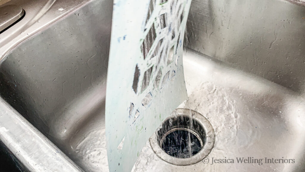 tile stencil being rinsed off in the kitchen sink