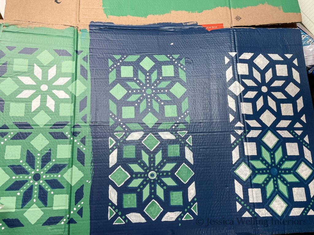Moroccan tile pattern painted on a piece of cardboard in several different color combinations