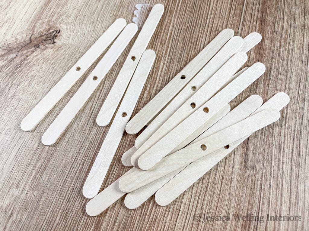 wooden wick holders for candle making on a countertop