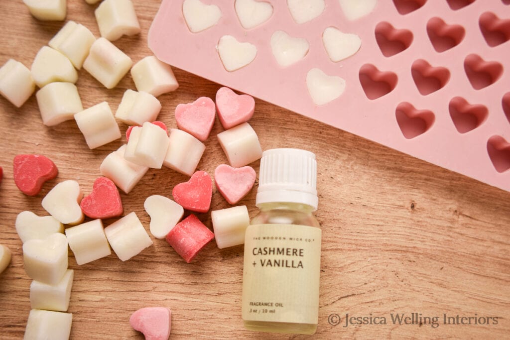 bottle of Cashmere & Vanilla candle fragrance oil with heart-shaped soy wax melts & a heart silicone wax mold